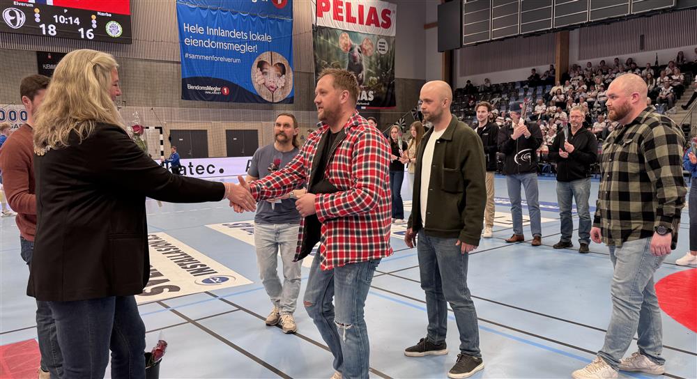 To personer som håndhilser i en idrettshall. - Klikk for stort bilde