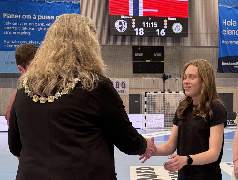 To personer som håndhilser i en idrettshall. - Klikk for stort bilde