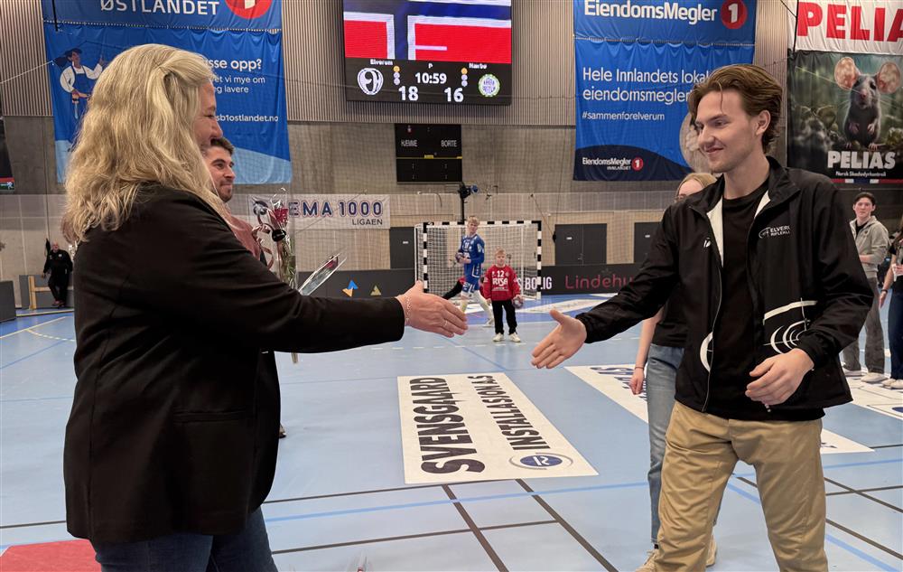 To personer som håndhilser i en idrettshall. - Klikk for stort bilde