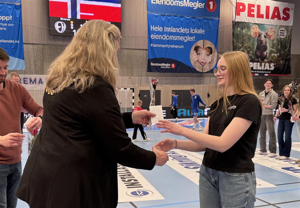 To personer som håndhilser i en idrettshall. - Klikk for stort bilde