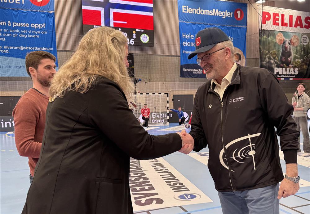To personer som håndhilser i en idrettshall. - Klikk for stort bilde