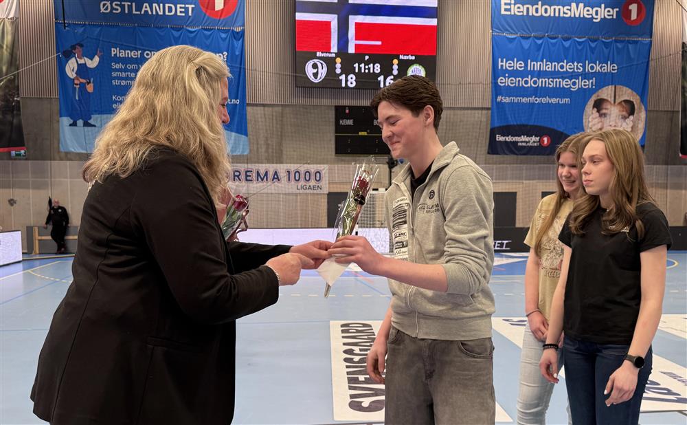 To personer som håndhilser i en idrettshall. - Klikk for stort bilde