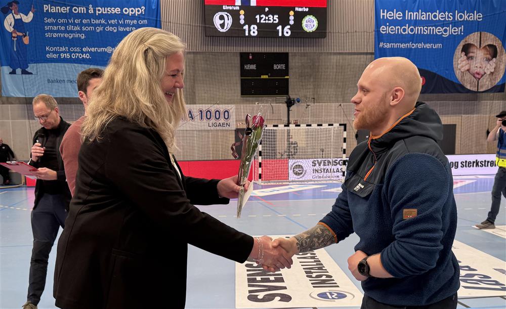 To personer som håndhilser i en idrettshall. - Klikk for stort bilde