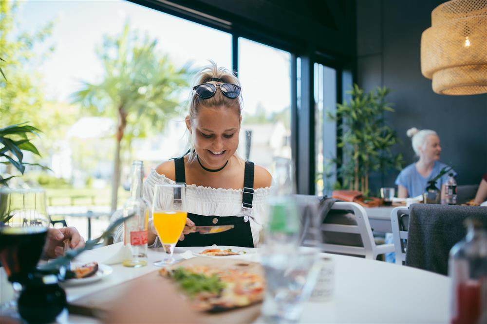 En dame som spiser mat i en restaurant. - Klikk for stort bilde