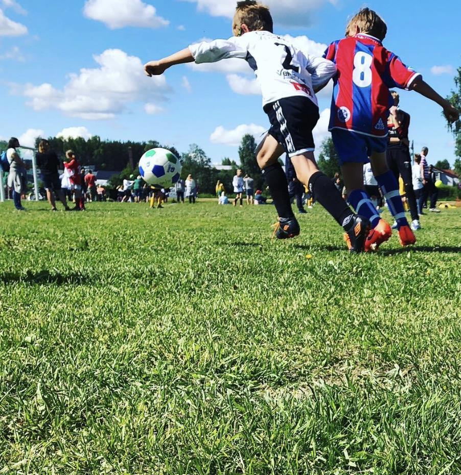 To barn som løper mot en fotball. - Klikk for stort bilde