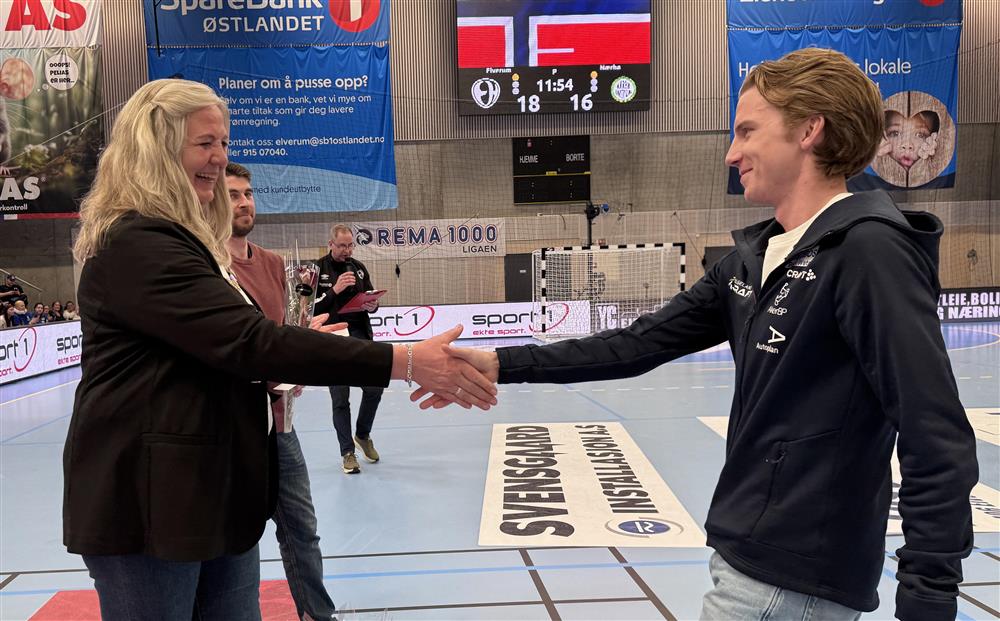 To personer som håndhilser i en idrettshall. - Klikk for stort bilde